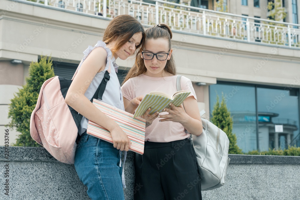 Outdoor portrait of two young beautiful girls students with backpacks ...