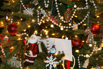 Christmas background of old fashioned tree with an eclectic variety of ornaments including santa and pearl garland and a gift envelope