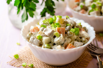 Wall Mural - Traditional Russian salad Olivier in bowls on wooden table. Selective focus.