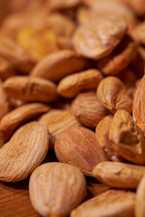 Scattered almond nuts on a brown background. Selective focus