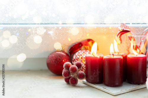 Christmas Styled Scene With Four Red Burning Candles On Windowsill