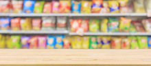 Wood Table Top With Supermarket Convenience Store Shelves With Potato Chips Snack Blur Abstract Background