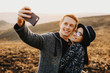 © Strelciuc - Attractive young man and woman hugging and smiling while posing for selfie in amazing countryside.Cheerful couple taking selfie in countryside