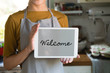 © Rawpixel.com - Woman holding a screen with the word welcome