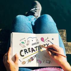 Wall Mural - woman drawing creative ideas in a notebook