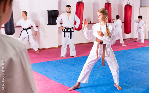 tween girl mastering new taekwondo moves during group class with male coach buy this stock photo and explore similar images at adobe stock adobe stock adobe stock