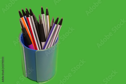 Fényképezés set of new bright colored pens lying in a penholder on a green background