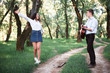 © soleg - young couple walking in the forest and playing guitar, summer nature, bright sunlight, shadows and green leaves, romantic feelings