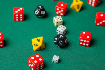 Collection of colored gaming dice cubes on green table