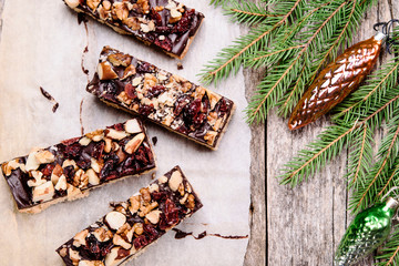 Wall Mural - Baked shortbread sticks with chocolate, chopped nuts and dried cranberries glazed. Millionaire's shortbread cookies and fir branches on vintage wooden table. Christmas baking