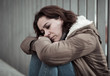 © SB Arts Media - Depressed woman sitting on urban city street overwhelmed and hop