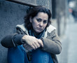© SB Arts Media - Depressed woman sitting on urban city street overwhelmed and hop