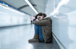 © SB Arts Media - Young desperate adult woman sitting on the ground on subway unde