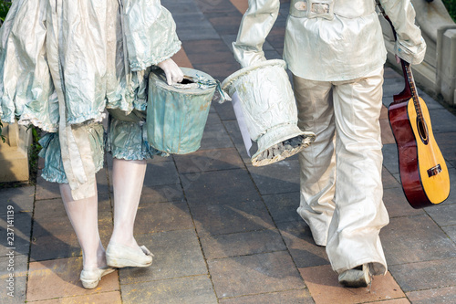 Photographie Pair of street artist painted in white silver paint walking in city park