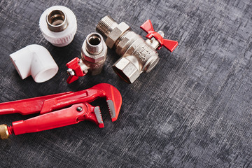 Wall Mural - plumbing tools and equipment on a black shabby background closeup with copy space