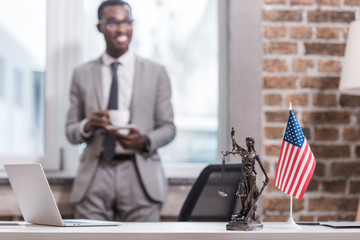 Wall Mural - Office desk and objects with african american businessman on background