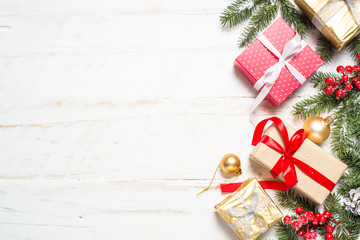 Red and Gold present box and decorations on white wooden backgro