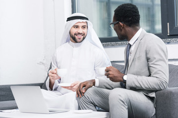 Wall Mural - Multicultural businessmen drinking coffee and taking in office