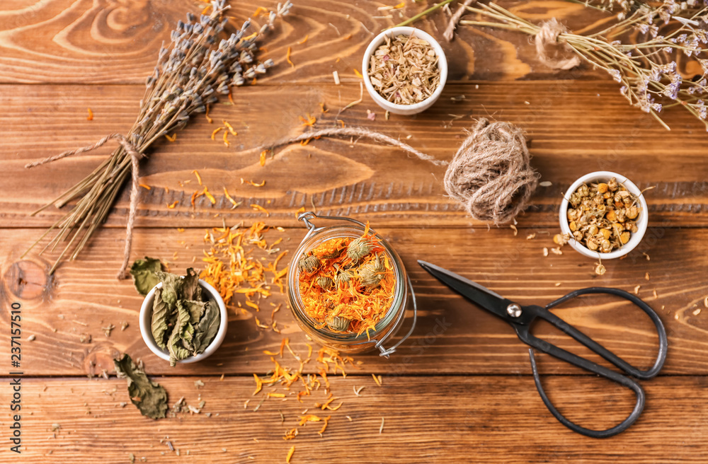 Dried herbs and flowers on wooden table