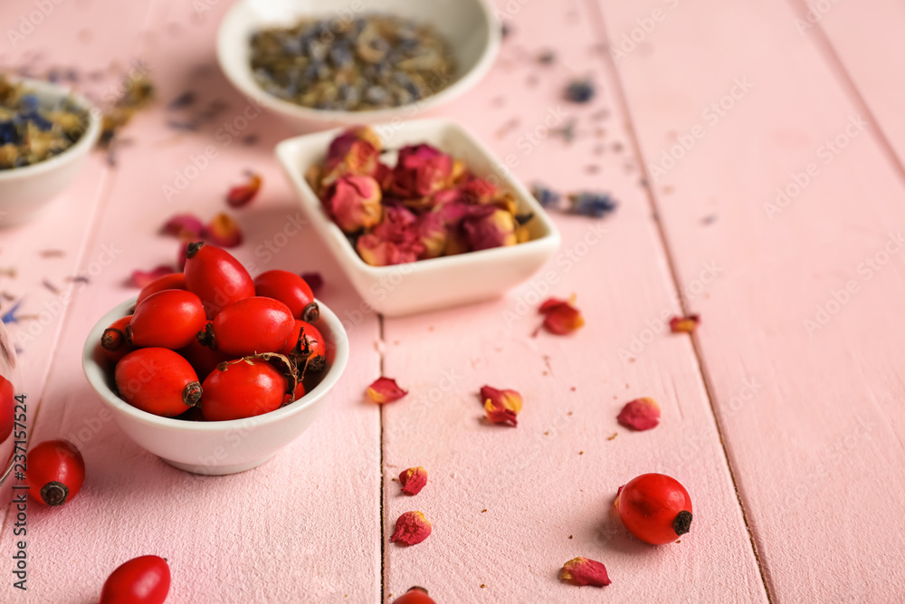 Dried rose hips on color wooden table