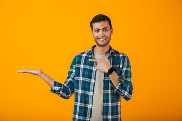 Cheerful young man wearing plaid shirt standing