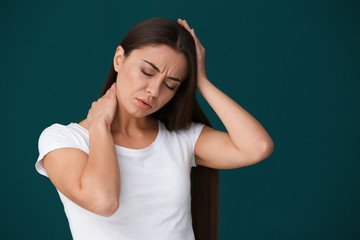 Woman suffering from headache on color background