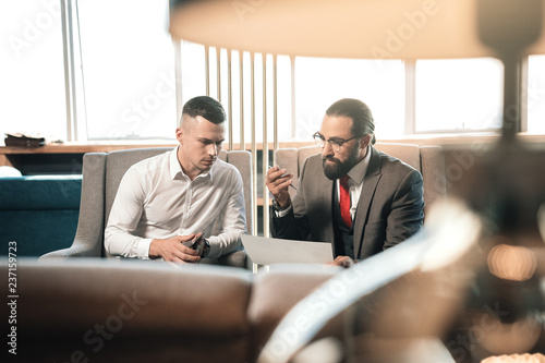 Fotografie, Tablou Dark-haired young trainee feeling confused listening to boss