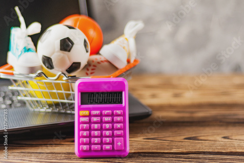 Sports Equipment In Market Basket On Old Dirty Laptop And Calculator Sports Equipment In Market Basket On Old Dirty Laptop And Calculator Brown Table Online Trade Concept