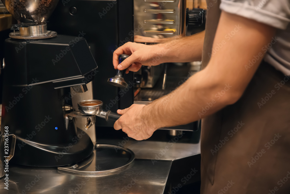 Barista preparing fresh aromatic coffee in cafe