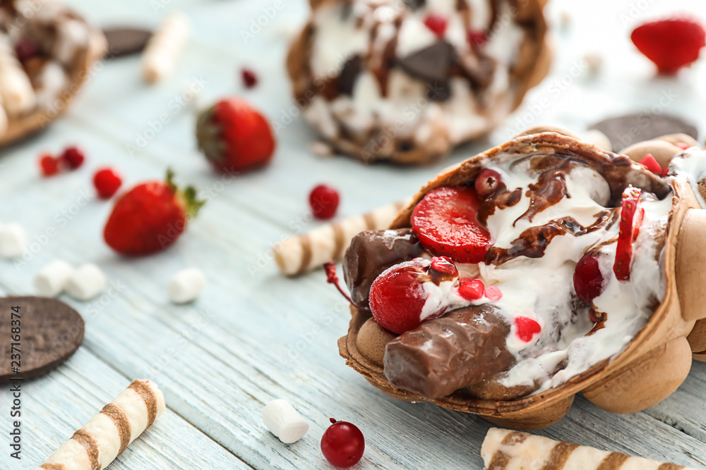 Delicious bubble waffle with ice cream on wooden table