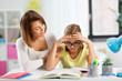 © Syda Productions - education, family and learning concept - mother helping daughter with difficult homework task at home