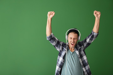 Canvas Print - Young man listening to music on color background