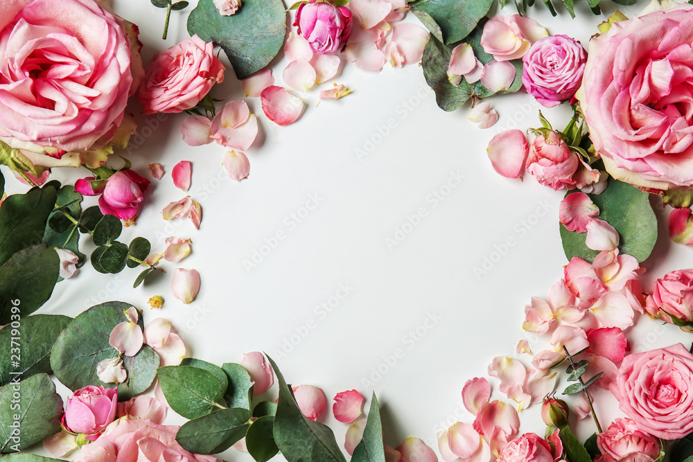 Beautiful frame made of pink roses and eucalyptus on white background