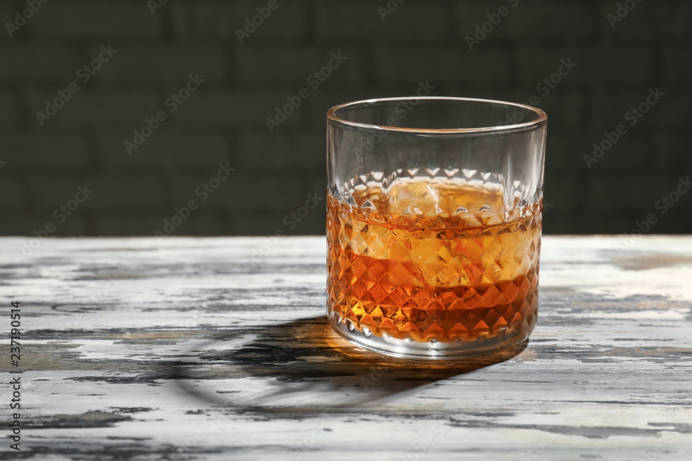 Glass of whiskey on wooden table