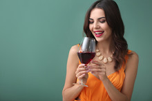 Beautiful Young Woman With Glass Of Wine On Color Background
