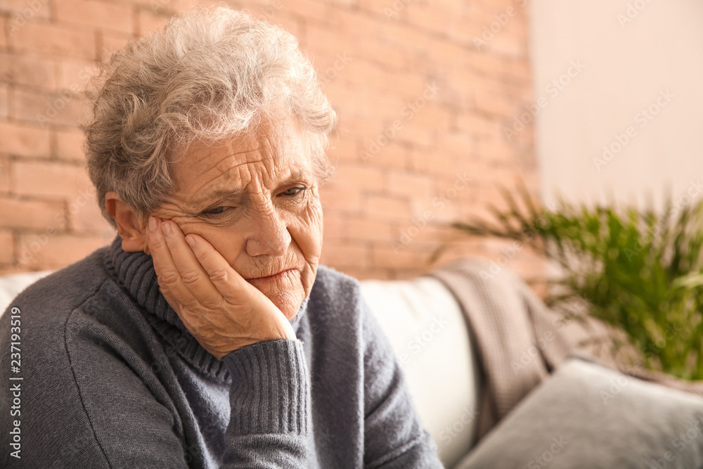 Senior woman suffering from toothache at home