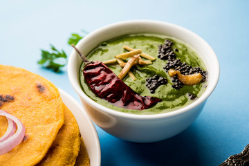 Makki di roti with sarson ka saag, popular punjabi main course recipe in winters made using corn breads mustard leaves curry. served over moody background. selective focus