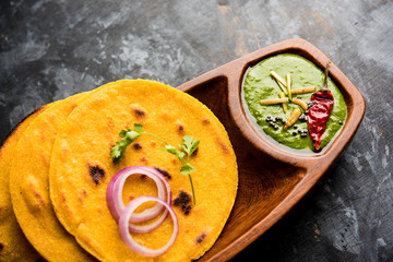 Makki di roti with sarson ka saag, popular punjabi main course recipe in winters made using corn breads mustard leaves curry. served over moody background. selective focus