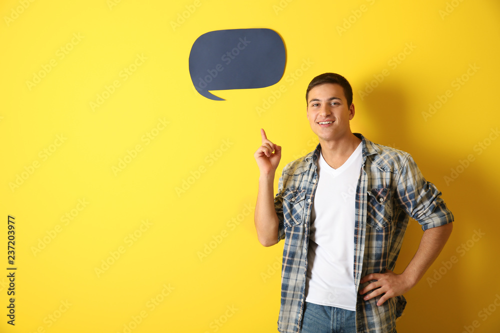 Young man with speech bubble on color background