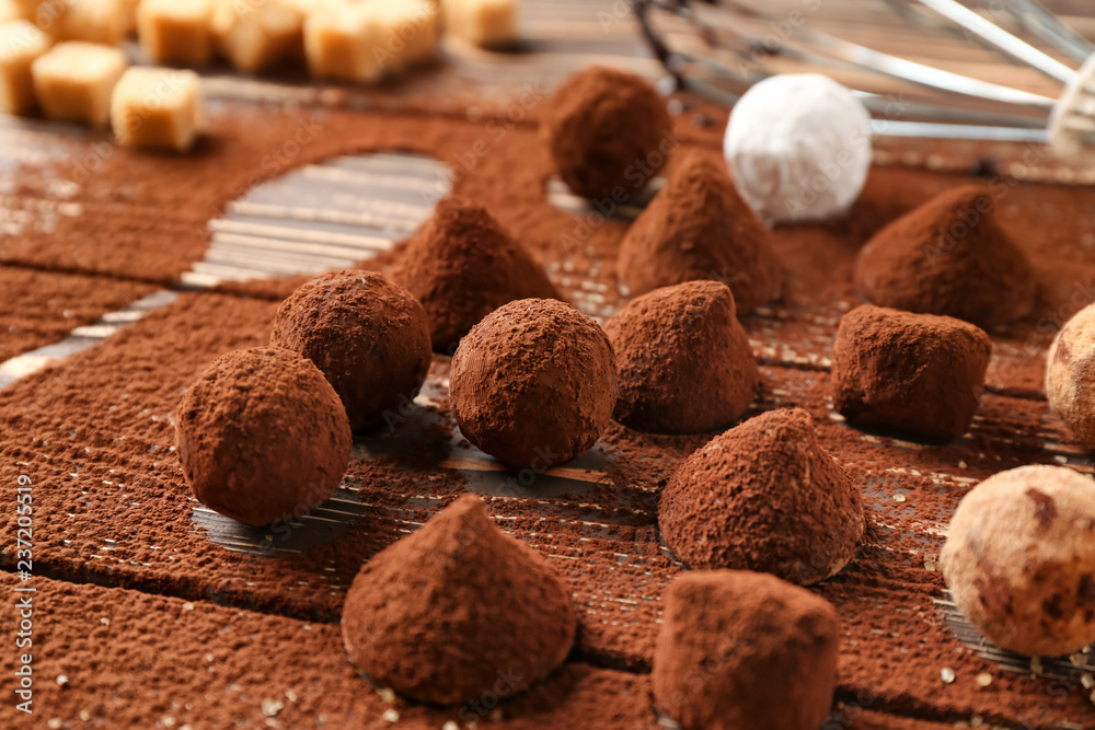 Tasty chocolate truffles powdered with cacao on table