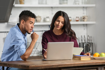 Young couple with laptop in kitchen