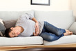 © Pixel-Shot - Young man suffering from abdominal pain at home