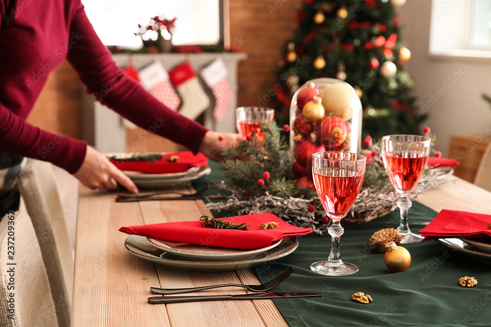 Woman setting the table for Christmas dinner