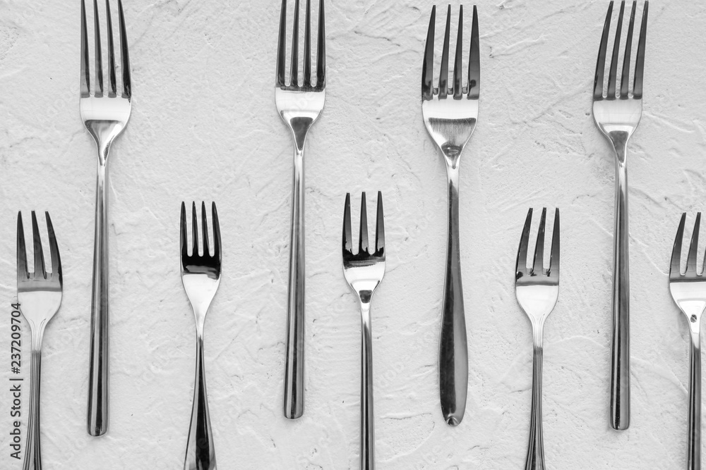 Many forks on white textured  background, flat lay