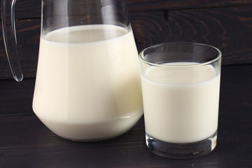 Poster - Milk in a jug and a glass on dark boards