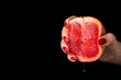 © Pixel-Shot - Woman squeezing half of juicy grapefruit on black background. Erotic concept