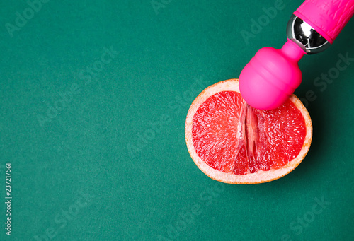 Fotografie, Obraz Vibrator and half of grapefruit on color background