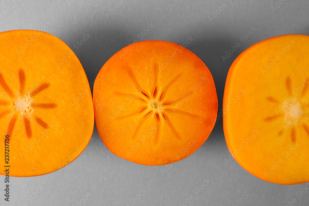 Sweet ripe persimmons on grey background, closeup