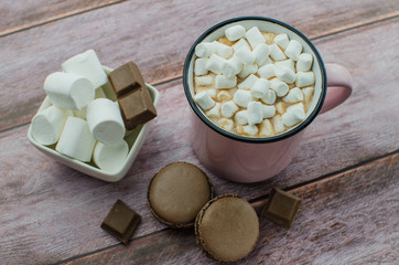 Cocoa drink with spices, zephyr on wooden background