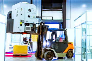 Forklift truck Loading equipment. Forklift raises the machine. Installation of equipment for production.